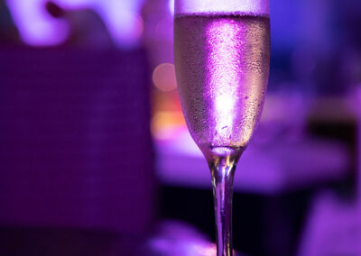 Foto: Champagnerglas erscheint in violettem Licht
