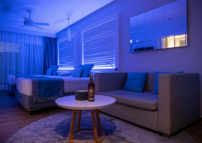 Foto: Hotelzimmer mit zwei Betten, Sofa und Beistelltisch inklusive Flasche Rum